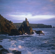 ENGLAND, Cornwall, Lands End, The Irish Lady stone stack below the cliffs with waves crashing