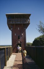 AUSTRALIA, Western Australia, Kalbarri, Visitors on walkway leading to whale watch tower.