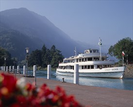 SWITZERLAND, Bern Oberland, Interlaken, White passenger ferry nearing quay with misty wooded