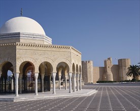 TUNISIA, Monastir, Bourguiba Mausoleum portico with white dome and Ribat Fortress behind