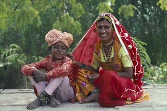 INDIA, Traditional Attire, Woman and young boy sitting together wearing traditional clothing.