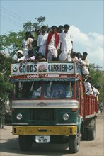 INDIA, Karnataka, Transport, Goods Carrier truck crowded with passengers.