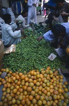 EGYPT, Upper Egypt, Luxor, Fruit and vegetable market with vendors and customers inspecting the