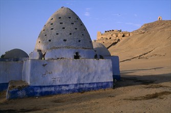 EGYPT, Upper Egypt, Aswan, Blue painted Beehive Mausoleum with Tomb of the Nobles on hilltop behind
