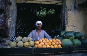 EGYPT, Upper Egypt, Luxor, "Fruit vendor outside shop selling green bananas, water melons and