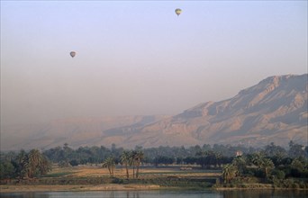EGYPT, Upper Egypt, Luxor, Valley of the Kings with two hot air balloons over the river Nile at
