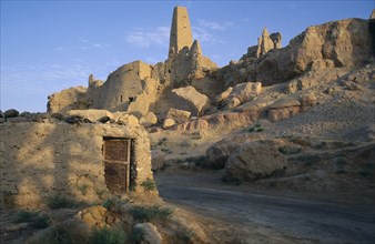 EGYPT, Western Desert, Siwa Oasis, Temple Of The Oracle 1 ruins on hillside above a road