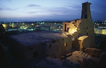 EGYPT, Western Desert, Siwa Oasis, View at dusk across rooftops with old minaret in foreground