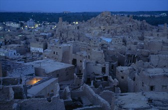 EGYPT, Western Desert, Siwa Oasis, View across town towards Shali Fortress at night with oasis in