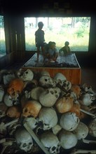 CAMBODIA, South Coast, Kampot, Children behind a pile of bones of Killing Field victims