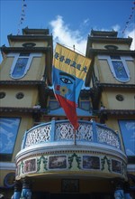 VIETNAM, An Long, Cao Dai Temple.  Detail of front portico and banner featuring the Divine Eye