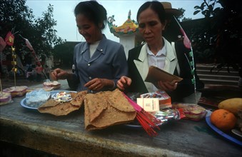 VIETNAM, Den Ba Chua Kho, Women preparing offerings.  temple rooftop just visible in background.