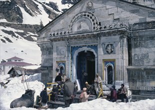 INDIA, Uttar Pradesh, Garhwal Region, Pilgrims in the snow at Kedarnath Temple one of the sources