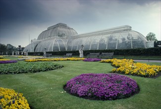 ENGLAND, London, Kew Gardens hot house with flower beds in the foreground.