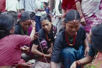 NEPAL, Religion, Young women receiving Tikas a mark of blessing on their forehead