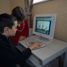 INDUSTRY, Computers, Children, Young boy and girl sitting at a home computer looking at educational