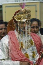 INDIA, Religion, Wedding, Portrait of  Sikh Bridegroom with gold and silver veil over his face.