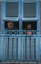 ITALY, Campania, Naples, San Giorgio a Cremano.  Elderly couple looking out from turquoise open