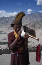 INDIA, Ladakh, Buddhist Tibetan monk blowing horn