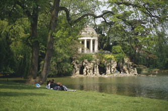 FRANCE, Ile de France, Paris, "Bois de Vincennes, couple on bank of Lake Daumesnil"