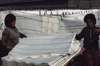 SOUTH KOREA, Crafts, Women stacking sheets of hand-made mulberry paper used for door and window