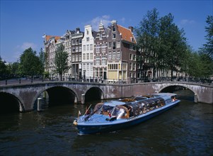 HOLLAND, Noord, Amsterdam, Tourist boat travelling down  the Keizersgracht canal