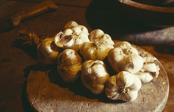 FRANCE, Food, Garlic lying on wooden board on table.