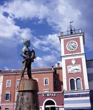 CROATIA, Rovinj, Clocktower with fountain statue of boy holding fish in the foreground
