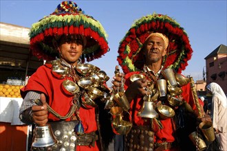 MOROCCO, Marrakech, Djemaa El Fna. Two water sellers wearing brightly coloured hats