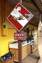 USA, Hawaii, Honolulu, Surf and dive shop sign with cartoon diver feeding a shark