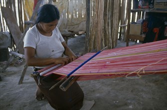 MEXICO, Quintana Roo, Chetumal, Woman weaving textile on hand loom at Los Liros Guatemalan refugee