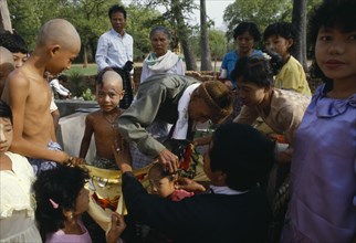 MYANMAR, People, Young boys having their heads shaved during novice monk initiation ceremony.