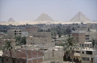 EGYPT, Cairo, City suburbs encroaching on the Pyramids at Giza.