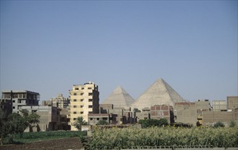 EGYPT, Cairo, City suburbs encroaching on the Pyramids at Giza.