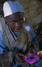 NIGERIA, Kano, Portrait of a local child playing a hand held computer game