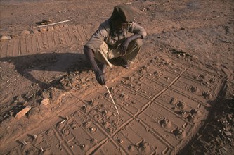 MALI, Pays Dogon, Bongo, A Dogon sand diviner indicating fox paw prints for telling fortunes.