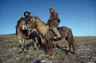 MONGOLIA, Transport, Two wolf hunters on Mountredon ponies in the autumn with frost on the ground