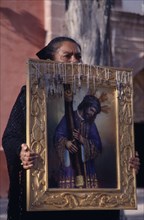 MEXICO, San Miquel de Allende, Mourner carrying portrait of Christ at Good Friday procession