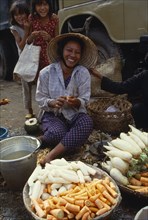 VIETNAM, South, Saigon, Smiling woman cleaning vegetables at a street market