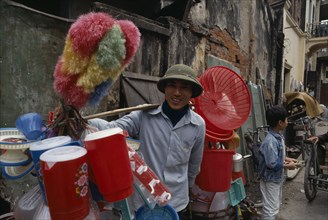 VIETNAM, North, Hanoi, Man carrying plastic goods for sale on the street