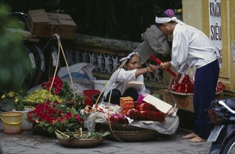 VIETNAM, North, Hanoi, Woman selling religious offerings from the pavement outside a temple