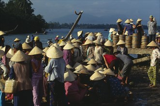 VIETNAM, Central, Hoi An, Women wearing traditional conical hats at the busy fish market beside the