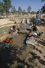 INDIA, Andhra Pradesh, Anantapur, Women washing clothes in irrigation outlet