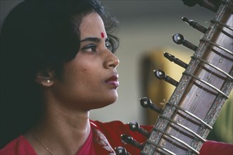 INDIA, Music, Female Indian musician playing the sitar.  Cropped view showing neck of instrument