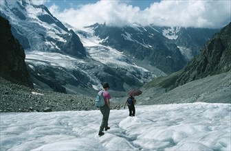 RUSSIA, Caucasus Mountains, Adyr Su Valley, Hikers walking down glacier wearing sun glasses and
