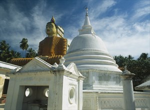 SRI LANKA, Wewurukannala Vihara, Giant seated Buddha constructed in 1970 with stupa in foreground.