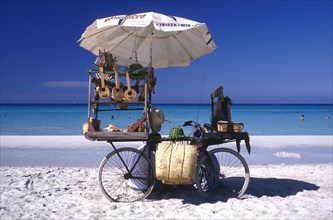 CUBA, Varadero, Beach vendors stall on a bycicle selling musical instruments and hats with clear