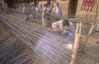 BANGLADESH, Dhaka, Welder welding the in suite reinforcement of a concrete pile of a high rise