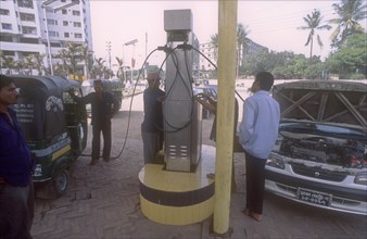 BANGLADESH, Dhaka, Men with car and LNG three wheeler taxi filling up on environmentally sound