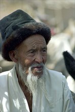 CHINA, Xinjiang, Kashgar, Portrait of an elderly man with a white beard wearing a fur rimmed hat